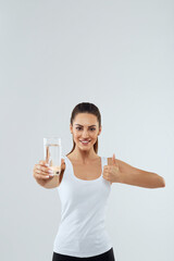 Portrait of beautiful woman on isolated studio background, hold water glass. Drink water. Diet...