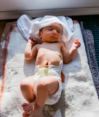 Newborn baby with diaper relaxing on blanket