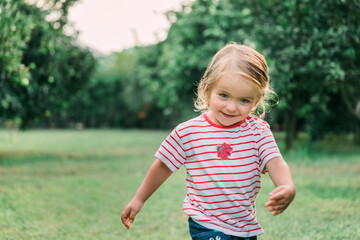 Toddler girl running in garden