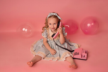 Happy baby girl on a pink background with balloons. Celebration. Birthday