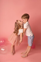 Happy child girl and boy on a pink background with balloons. Celebration. birthday