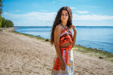 girl walks on the beach, posing against the background of the sea