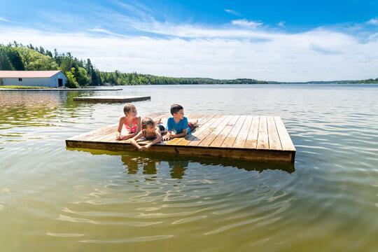 Children laying on a raft on a lake during summer