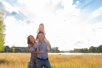 Happy family at sunset in the field
