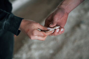 Selling and buying illegal drugs. Close up view of man's and woman's hands with package