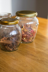 Glass jars with cinnamon and tea stand on a light wooden table

