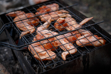 Сырые куриные крылышки на решетке барбекю