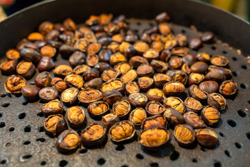 Roasted chestnuts in a frying pan in the street market.