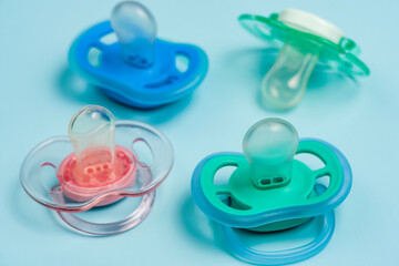 One blue plastic nipple pacifier soother on a blue background, space for text