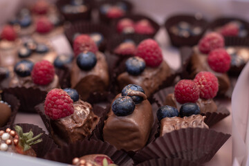 Beautiful chocolates, sweets with berries and fruits, festive treats, diabetes, obesity problems, food that spoils the figure