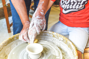 Children making pottery during ceramic lesson with clay