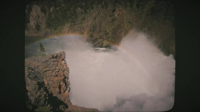 A view of Lower Yellowstone Falls and a rainbow in Yellowstone National Park. Vintage Film Look.