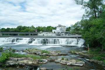 Slow motion river and waterfall in a small town