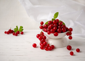 Fresh red currant berries lie in a Cup on a white background. soft focus