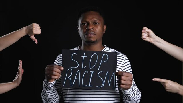 People bullying African-American man on dark background. Stop racism