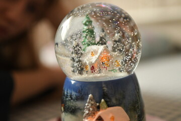 Blurry background girl looking at the snowball as a christmas gift