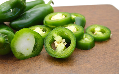 A pile of finely chopped chilli peppers on wooden board on a white background