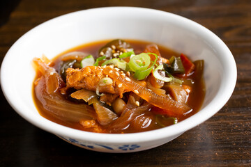 A view of a small sauce of marinated uni, in a restaurant or kitchen setting.