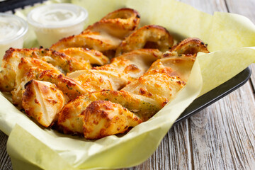 A closeup view of a basket of bread twists, in a restaurant or kitchen setting.