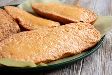 A closeup view of several halves of garlic bread appetizer, in a restaurant or kitchen setting.