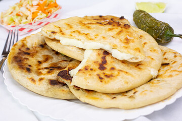 A view of a stack of pupusas, in a restaurant or kitchen setting.