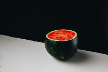 Half of a small fresh watermelon with white and black background