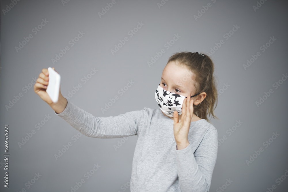 Sticker Caucasian female child with a medical face mask taking a selfie - protection from Covid-19 concept