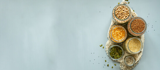 Organic bio bulk products in zero waste shop. Foods storage in kitchen at low waste lifestyle. Cereals and grains in glass jars on table. Eco friendly shopping in plastic free grocery store.