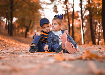 Cute boy and girl in autumn park.