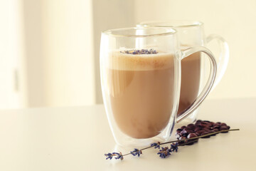 Tasty coffee with lavender on light background