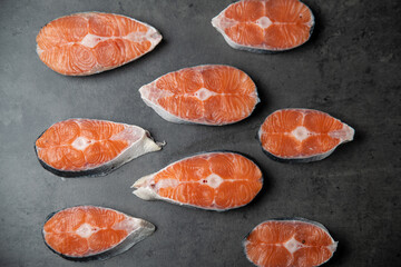 raw salmon steaks on black background