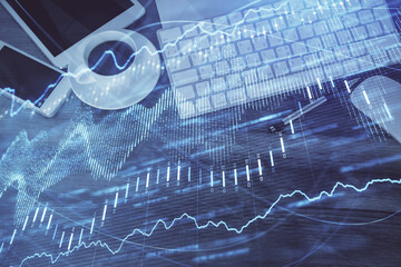 Double exposure of forex chart hologram over desktop with phone. Top view. Mobile trade platform concept.
