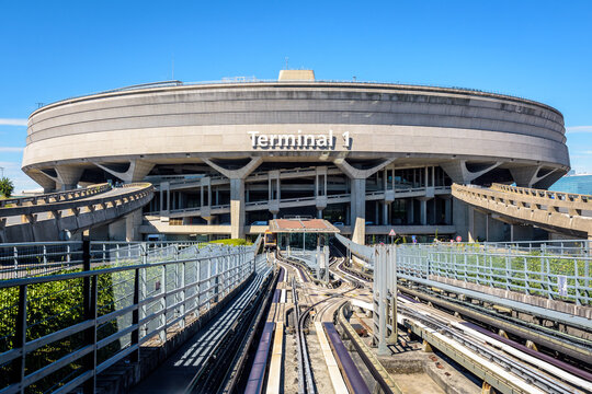 Roissy-en-France, France - July 27, 2020: Front view of the Terminal 1 circular concrete building of Paris-Charles de Gaulle Airport, seen from the CDGVAL airport shuttle on a sunny day.