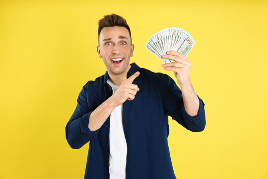 Emotional Man With Cash Money On Yellow Background