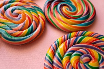 Fototapeta na wymiar Colorful swirl lollipops arranged on a pink background.
