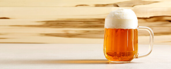 Beer mug with a fresh draft beer on an outddor table. Copy space for text.