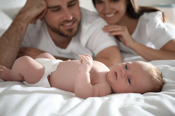 Obraz na płótnie Canvas Happy couple with their newborn baby on bed, closeup