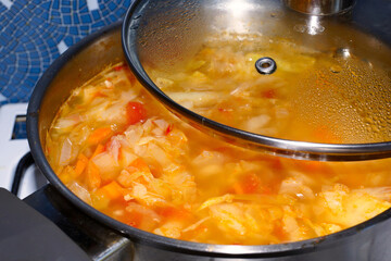 Cabbage soup in a saucepan. Making homemade soup. Close-up