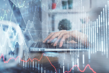 Double exposure of woman hands typing on computer and forex chart hologram drawing. Stock market invest concept.