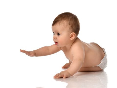 Portrait of sweet cute baby boy toddler in diapers crawling on floor with raised hand