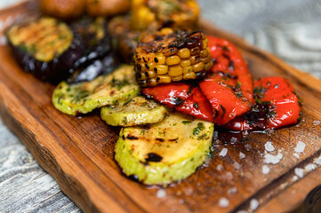 Various tasty grilled vegetables and mushrooms on rustic background