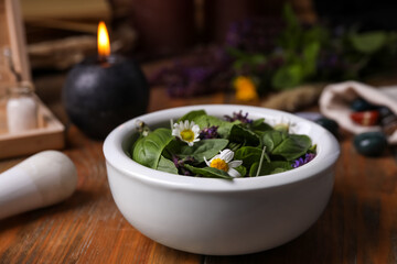 Composition with mortar, healing herbs and gemstones on wooden table, closeup