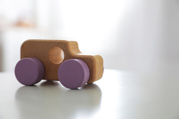 Wooden car on white table indoors. Space for text