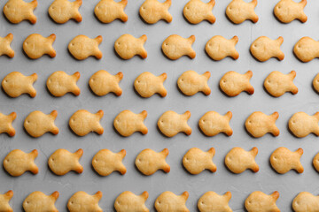 Delicious goldfish crackers on grey table, flat lay