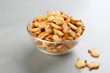 Delicious goldfish crackers in bowl on grey table