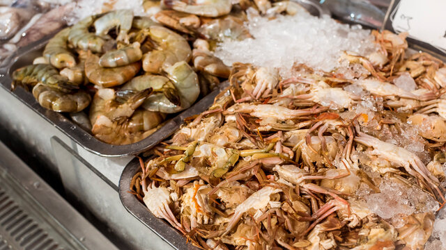 Juicy prawns and baby crabs on display at the seafood section of a supermarket or marketplace.