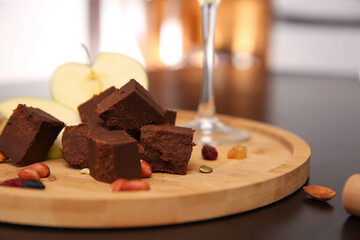Delicious brunost cheese and nuts on table, closeup