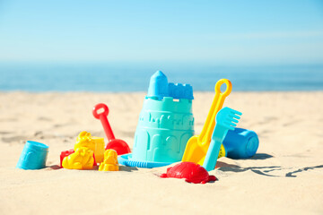Fototapeta na wymiar Different child plastic toys on sandy beach