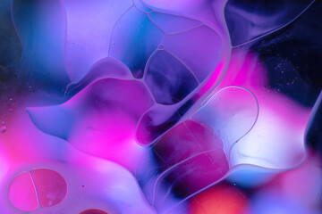 Water and oil droplets on colourful shape, background.