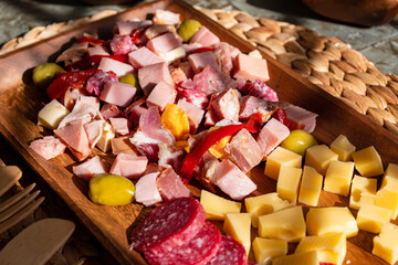 
food prepared with cheeses and cold cuts on a wooden tray and wicker to enjoy with the family